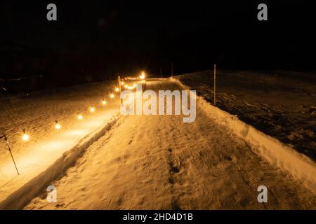 Saint Margrethenberg, Svizzera, 19 dicembre 2021 strada pedonale coperta di neve di notte illuminata con luci Foto Stock