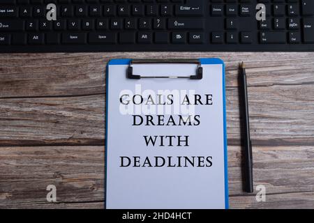 Citazione motivazionale scritta su appunti blu con tastiera e penna Foto Stock