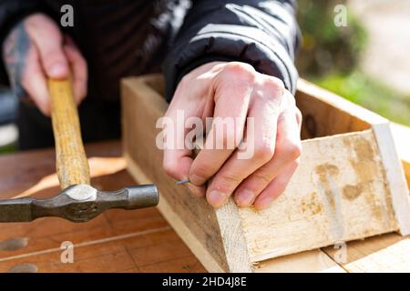 Primo piano di una persona che batte insieme un progetto DIY. Fai da te, costruzione, concetto di miglioramento della casa Foto Stock