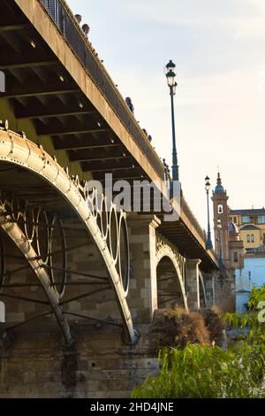 Ponte Triana a Siviglia sul fiume Guadalquivir. Tramonto. Foto Stock