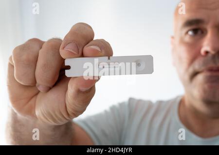 l'uomo mostra un primo piano di un test negativo dell'antigene covidico. Foto Stock