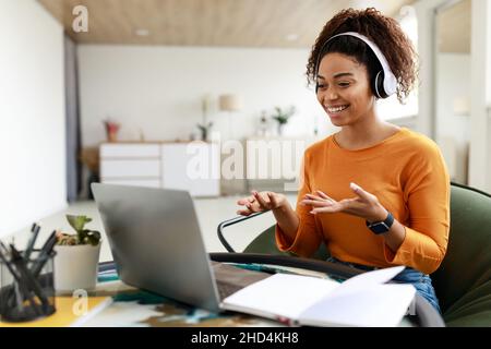 Donna nera che ha una videochat con un computer portatile e parla con la webcam Foto Stock