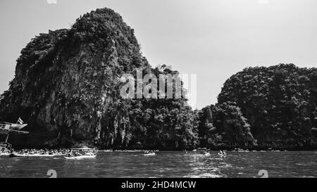 Foto in scala di grigi di ripide scogliere e foreste di mangrovie nel Parco Nazionale Ao Phang Nga, Thailandia Foto Stock