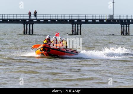 La scialuppa di salvataggio RNLI come sicurezza per i nuotatori nel mare dell'estuario del Tamigi a Southend on Sea, Essex, Regno Unito, per una nuotata di beneficenza di Capodanno per gli RNLI Foto Stock