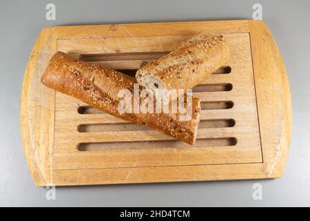 Pezzi di pane tradizionale francese baguette su un tagliere Foto Stock