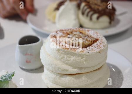 Soffici pancake giapponesi al Fuwa Fuwa di Londra, serviti con sciroppo e burro a nido d'ape. Foto Stock