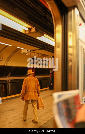 Colpo verticale di un vecchio che esce dalla metropolitana in una stazione della metropolitana Foto Stock