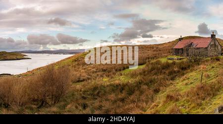 Un vecchio croft in rovina a Caolas Scalpaigh che domina Loch an Tairbeairt e il Ponte Scalpay. Foto Stock