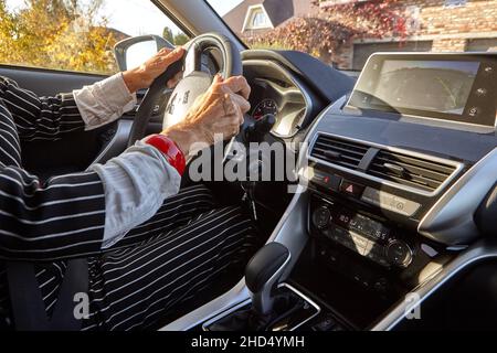 Donna anziana alla guida di un'auto costosa Foto Stock