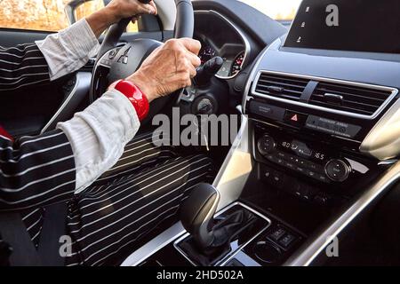 Donna anziana alla guida di un'auto costosa Foto Stock