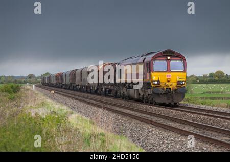 DB Cargo Rail classe 66 Locomotiva diesel 66053 che trasporta un treno merci di carri in acciaio attraverso la campagna inglese Foto Stock