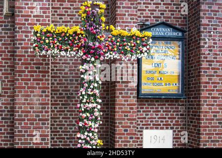 Croce abbellito con fiori di primavera durante la Quaresima Foto Stock