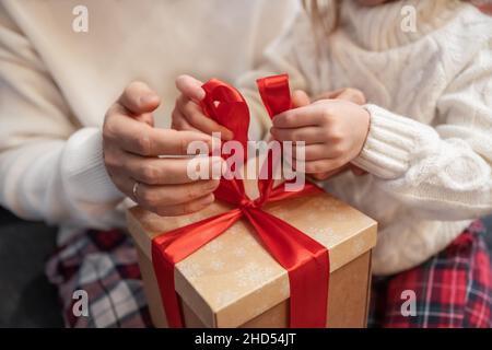 padre insegna a figlia di avvolgere un regalo di natale Foto Stock