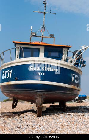 Barca da pesca sulla spiaggia di ghiaia sopra l'acqua alta. Dungeness, Kent, Inghilterra, Regno Unito Foto Stock