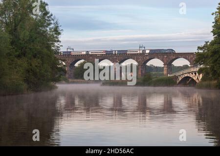 Avanti costa occidentale Alstom Pendolino treno ad alta velocità che attraversa il viadotto di Dutton sulla linea principale della costa occidentale a Cheshire in una mattinata di nebbia Foto Stock