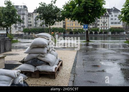 Un mucchio di sacchi di sabbia su palette, pronto per la protezione dalle alluvioni nella città di Lucerna Foto Stock