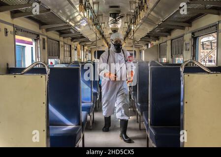 Un pulitore tailandese che indossa un equipaggiamento protettivo personale (PPE) spruzza disinfettante sui sedili dei passeggeri nella cabina di un treno, come misura preventiva contro la diffusione del COVID-19, presso la stazione ferroviaria di Hua Lamphong a Bangkok.il Dipartimento per il controllo delle malattie della Thailandia sta conducendo test COVID-19 di massa sui passeggeri in arrivo, La maggior parte di loro tornano a casa per le celebrazioni del nuovo anno, mentre il paese intensifica gli sforzi per prevenire la diffusione della malattia del coronavirus (COVID-19), il Ministero della Salute della Thailandia ha riferito oggi mattina che più di 1.780 casi di Omicron erano stati scoperti in tailandese Foto Stock