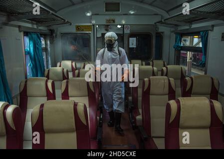 Un pulitore tailandese che indossa un equipaggiamento protettivo personale (PPE) spruzza disinfettante sui sedili dei passeggeri nella cabina di un treno, come misura preventiva contro la diffusione del COVID-19, presso la stazione ferroviaria di Hua Lamphong a Bangkok.il Dipartimento per il controllo delle malattie della Thailandia sta conducendo test COVID-19 di massa sui passeggeri in arrivo, La maggior parte di loro tornano a casa per le celebrazioni del nuovo anno, mentre il paese intensifica gli sforzi per prevenire la diffusione della malattia del coronavirus (COVID-19), il Ministero della Salute della Thailandia ha riferito oggi mattina che più di 1.780 casi di Omicron erano stati scoperti in tailandese Foto Stock