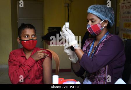 Mumbai, India. 03rd Jan 2022. Un operatore sanitario si prepara a somministrare una dose di vaccino Covaxin ad uno studente della scuola Sainath a navi Mumbai.in India è stata lanciata la vaccinazione per i bambini di età compresa tra i 15-18 e i 24 anni. Credit: SOPA Images Limited/Alamy Live News Foto Stock