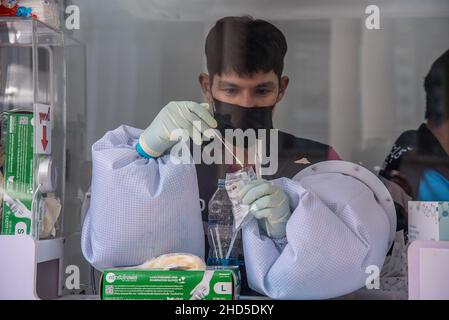 Un operatore sanitario prepara un test del tampone nasale durante il test COVID-19 per i viaggiatori presso la stazione ferroviaria di Hua Lamphong a Bangkok.Thailand's Department of Disease Control sta conducendo test COVID-19 di massa sui passeggeri in arrivo, la maggior parte dei quali torna a casa per le celebrazioni del nuovo anno, Mentre il paese intensifica gli sforzi per prevenire la diffusione della malattia del coronavirus (COVID-19), il Ministero della Salute della Thailandia ha riferito oggi mattina che più di 1.780 casi di Omicron erano stati scoperti in Thailandia. (Foto di Peerapon Boonyakiat/SOPA Images/Sipa USA) Foto Stock