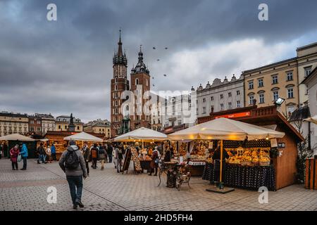 Cracovia, Polonia-Dicembre 17,2021. Famoso mercato di Natale sulla piazza principale, Rynek Glowny, capanne in legno decorate con formaggio affumicato, vino caldo e altri polacchi Foto Stock