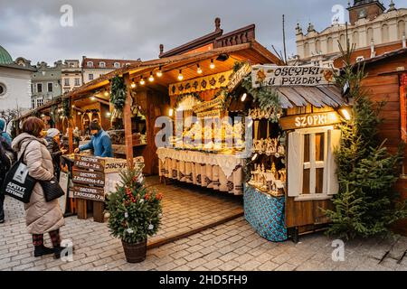 Cracovia, Polonia-Dicembre 17,2021. Famoso mercato di Natale sulla piazza principale, Rynek Glowny, capanne in legno decorate con formaggio affumicato, vino caldo e altri polacchi Foto Stock