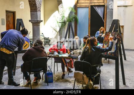 Gli studenti di pittura creano tele d'arte su cavalletti in un cortile all'aperto in classe a San Miguel de Allende, Messico Foto Stock