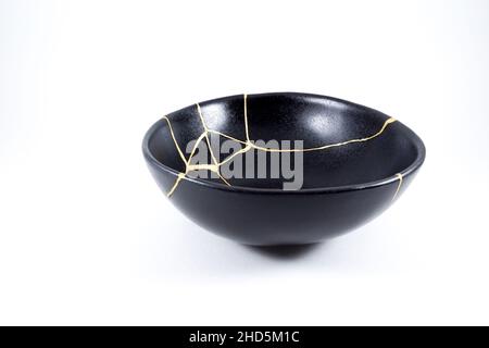 Kintsugi oro crepe restauro, giapponese nero ciotola fissato con l'antica tecnica di restauro kintsukuroi, la bellezza delle imperfezioni, rappresentano Foto Stock