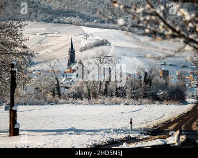 Un'antica città alsaziana sotto la neve. Il campanile della cattedrale e i tetti delle case medievali. Francia. Foto Stock