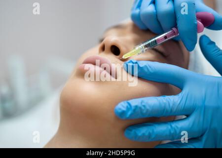 Primo piano della procedura di aumento e correzione delle labbra. Iniezione di acido ialuronico Foto Stock