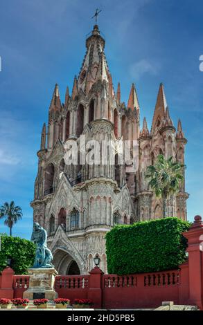 Vista della spettacolare cattedrale neogotica di Parroquia de San Miguel Arcangelo del 17th secolo rosa con la statua di Fray Juan, San Miguel de Allen de, MX Foto Stock