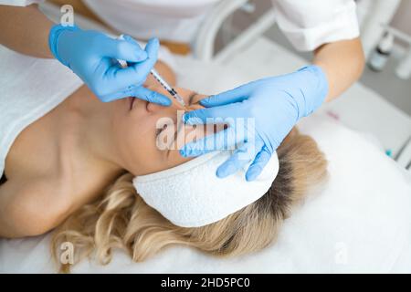 Cosmetologo ringiovanente e anti rughe iniezioni sul volto della donna. Cosmetologia estetica femminile in un salone di bellezza Foto Stock