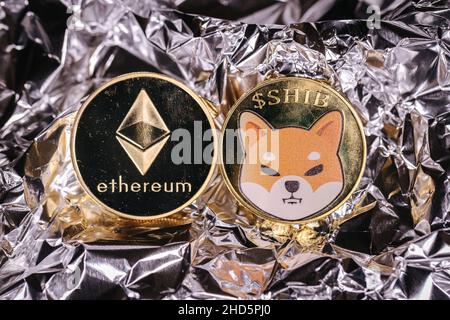 Ethereum e Shiba Inu criptovaluta, monete fisiche di fronte ad uno sfondo astratto. Foto Stock