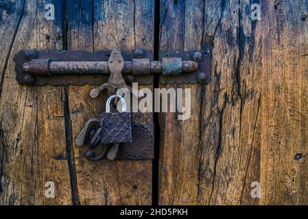 Primo piano delle vecchie porte in legno con chiusura a vite esterne con maniglia in gecko art, metallo ornamentale forgiato a mano a San Miguel de Allende, Messico Foto Stock