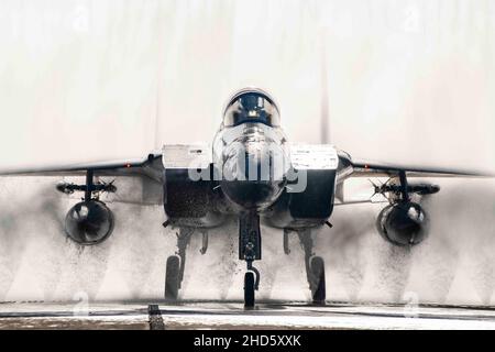 Base aerea di Kadena, Okinawa, Giappone. 8th Dic 2021. Un F-15C Eagle assegnato ai 67th Fighter Squadron taxi attraverso il bagno di uccelli dopo un addestramento sortie alla base aerea di Kadena, Giappone, 8 dicembre 2021. Il velivolo viene lavato più frequentemente in un ambiente di acqua salata per combattere la corrosione, tipicamente alla fine di ogni giornata di volo. Credit: U.S. Air Force/ZUMA Press Wire Service/ZUMAPRESS.com/Alamy Live News Foto Stock