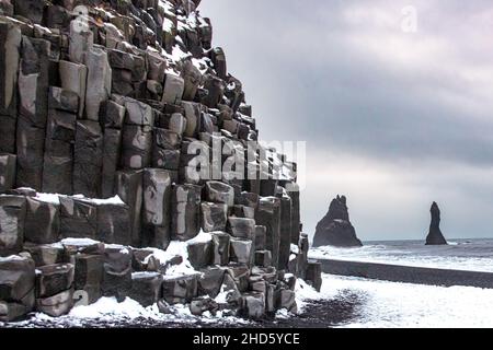 Reynisdrangfer Seastacks al largo di Reynisfjara Beach come visto dalla Grotta di Halsanefshellir Foto Stock