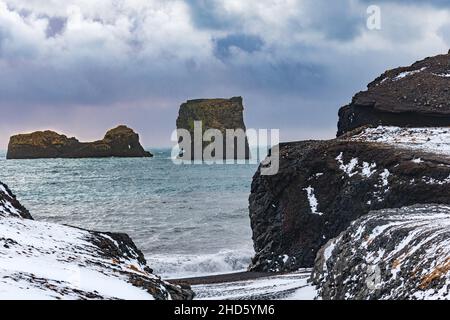 Le onde battono contro le rocce di basalto nero di Reynisfjara Foto Stock