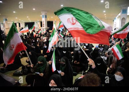 Teheran, Iran. 03rd Jan, 2022. Le donne velate agitarono la bandiera iraniana durante il secondo anniversario dell'assassinio di Qassem Soleimani. L'ex corpo di Guardia rivoluzionaria islamica (IRGC) il generale della forza Qasem Soleimani fu ucciso in un attacco con droni americani all'aeroporto di Baghdad. (Foto di Sobhan Farajvan/Pacific Press) Credit: Pacific Press Media Production Corp./Alamy Live News Foto Stock