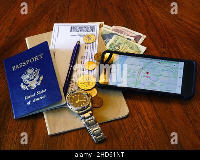 Lake Elsinore, CA, USA 3 gennaio 2022 biglietti aerei, passaporto, telefono e carta di credito su sfondo di legno. Vista dall'alto. Foto Stock