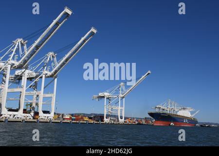Tugs docking nave container APL Presidente Eisenhower, Porto di Oakland. Trasporto commerciale e navi container a San Francisco Bay, California Foto Stock