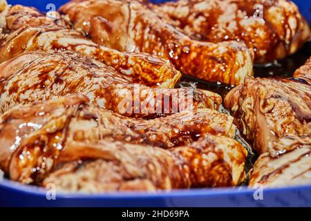 Cosce di pollo marinate con salsa di soia in un recipiente speciale Foto Stock