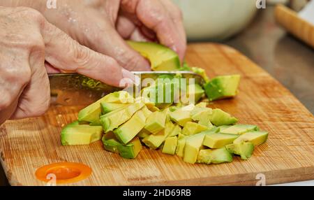 Cuocete a fette l'avocado maturo per preparare l'insalata Foto Stock
