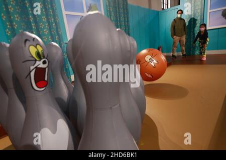 Taipei, Taipei, Taiwan. 4th Jan 2022. Un bambino e suo padre sono visti giocare ad uno stand, ad una Tom and Jerry Exhibition a Taipei, come situazione Covid rimane stabile a Taiwan. La mostra di Tom e Jerry, che è un'animazione americana tradizionale e di fama mondiale dell'intrattenimento Warner Brothers, durerà fino al 28 febbraio 2021. (Credit Image: © Daniel Ceng Shou-Yi/ZUMA Press Wire) Credit: ZUMA Press, Inc./Alamy Live News Foto Stock