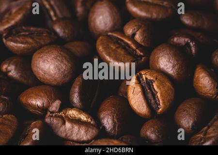 Chicchi di caffè arrosto fondo telaio pieno primo piano macro marrone scuro Foto Stock