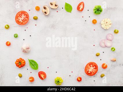 Gli ingredienti per la pizza fatta in casa sono allestiti su fondo di cemento bianco. Foto Stock