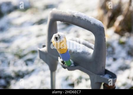 ghiaccio in un tubo dell'acqua del carrello del giardino, colpo macro esterno Foto Stock