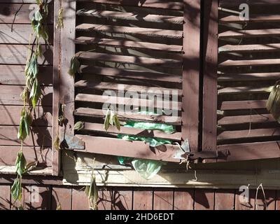 Vecchia casa apparentemente abbandonata con persiane di legno chiuse Foto Stock
