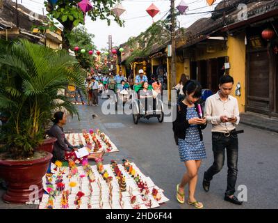 Hoi An, Vietnam - 13 marzo 2016: Strada della città vecchia piena di turisti e venditori in serata Foto Stock