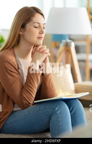 donna che prega sulla bibbia santa al mattino Foto Stock