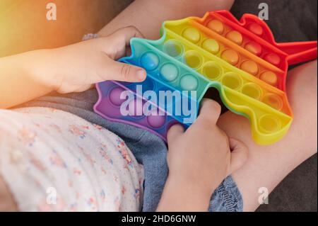 Premi la bolla colorata nel giocattolo popit. Trend gioco per bambini Foto Stock